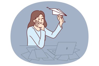 Motivasyonsuz serbest çalışan kadın ofis masasında dizüstü bilgisayarla oturup kağıt uçaklar fırlatıyor. Motivasyonsuz ofis çalışanının yöneticinin desteğine ya da patinaj için yardıma ihtiyacı var.