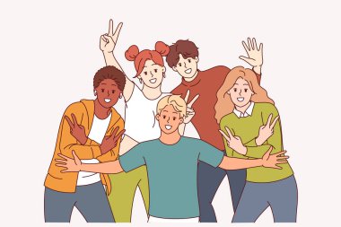 Bir grup çok ırklı öğrenci, olumlu duygular ve Ziyaretçi jestleri sergileyen grup fotoğraflarına poz veriyor. Kızları olan, gülümseyen ve ekrana bakan çeşitli genç erkekler neşe ve beraberliği gösteriyor..