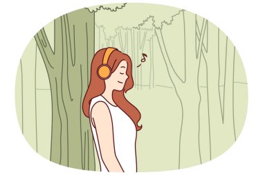 Kadın kulaklıkla müzik dinliyor. Uzun ağacın yanında duruyor ve güzel havanın ve temiz havanın tadını çıkarıyor. Genç kız müzik dinler. Okulda geçirdiği yorucu bir günden sonra doğada tek başına dinlenir.