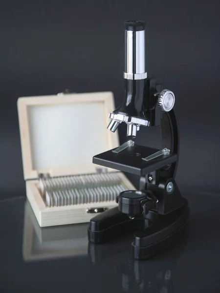 microscope with accessories on a black background