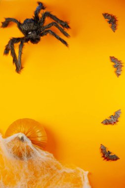 Turuncu arka planda örümcekler, örümcekler ve örümcek ağlarıyla Cadılar Bayramı