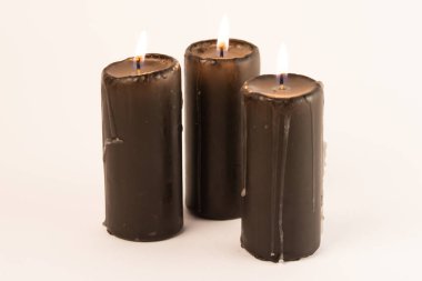 Beyaz arka planda üç mum. Sığ alan derinliği.