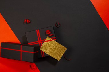 Siyah arka planda kırmızı kurdeleli siyah hediye kutuları. Üst görünüm.