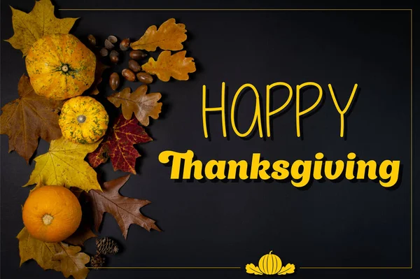 Happy Thanksgiving card with pumpkins and autumn leaves on a black background