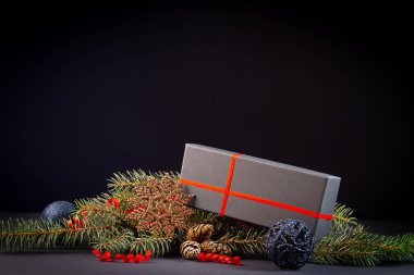  Noel ağacı, süslemeler ve siyah arka planda bir hediye kutusu.