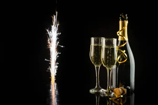 Champagne glasses and alarm clock on black background. New Year concept. New Year and Christmas celebration concept.