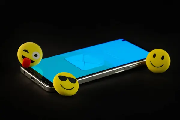 Mobile phone with smiley faces and emojis.