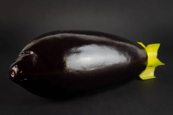 eggplant and carom looks like a mortar shell. The concept of healthy eating. On a black background.