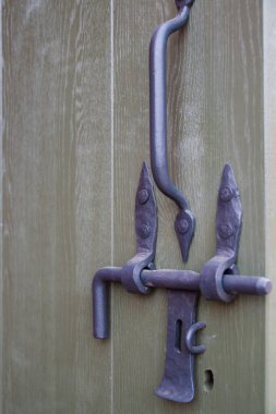 Eski ahşap kapısında sapları olan metal bir kapı.