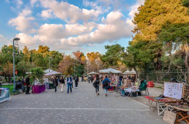 Athens, Greece - January 7 2023: The open flea market on Apostolou Pavlou pedestrian st. The Agion Asomaton park is on the left and the Ancient Agora on the right.