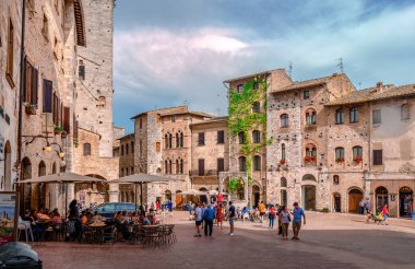 San Gimignano, İtalya - 27 Mayıs 2018: Yeraltı sarnıçlarının (sarnıçların) adı verilen Piazza della Cisterna manzarası. 1287 yılında inşa edilen bina, evler ve kulelerle çevrilidir..