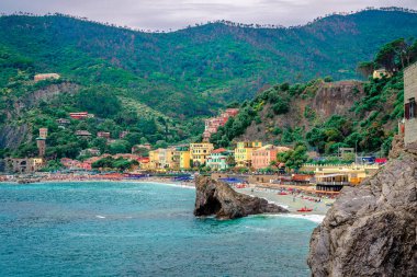 Spiaggia di Fegina plajı manzarası ve UNESCO 'nun miras listesindeki ulusal bir park olan Cinque Terre' nin en batısındaki Monterosso al Mare limanı. La Spezia, İtalya.