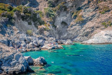 Amorgos, Yunanistan - 27 Temmuz 2024: Agia Anna plajında yüzücüler, muhteşem güzellikteki küçük kayalık bir plaj, Amorgos Adası 'ndaki' Büyük Mavi 'filmindeki sahneleriyle ünlü,.