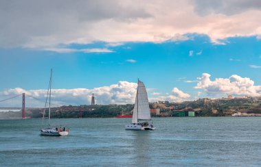 Belem, Portekiz - 25 Ekim 2024: Tagus Nehri manzarası. Arka planda İsa 'nın Mabedi' nin dev heykeli olan Almada ve 25 de Abril köprüsü solda..