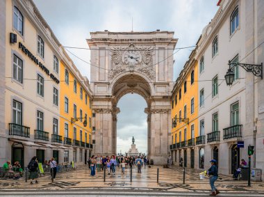 Lizbon, Portekiz - 24 Ekim 2024: Rua Augusta Kemeri, Praca do Comercio 'daki anıta benzeyen tarihi bina, arka planda Kral Jose' nin heykeli bulunuyor..