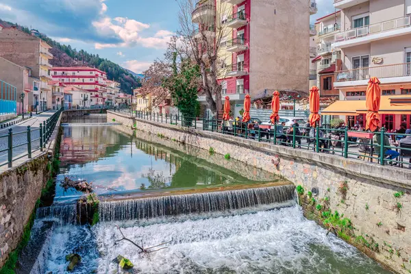 Florina, Yunanistan - 16 Mart 2024: Sakoulevas nehri kıyı şeridinde iskan binaları ve kaldırım kafesi.