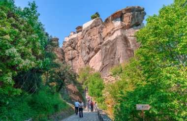 Kalambaka, Yunanistan - 14 Nisan 2024: Meteora 'daki insanlar Kalambaka' dan Kutsal Üçleme Manastırı 'na (nam-ı diğer Agia Triada) doğru yürüyüş yapıyor.