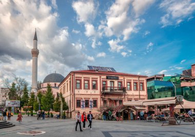 Bitola, Kuzey Makedonya - 16 Mart 2024: Kaldırım kafeleri ve arka planda Ishak Celebi Camii bulunan Magnolia Meydanı.