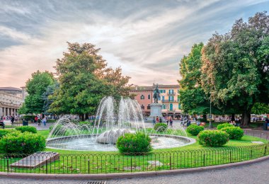 Verona, İtalya - 24 Mayıs 2018: Arka planda Palazzo della Gran Guardia ile Piazza Bra 'daki bahçe ve çeşme manzarası.