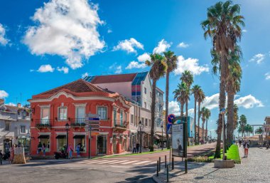 Cascais, Portekiz - 27 Ekim 2024: Alameda Cobatentes da Grande Guerra Bulvarı şehir merkezinde güzel renkli binalar ve palmiye ağaçları ile manzaralı.