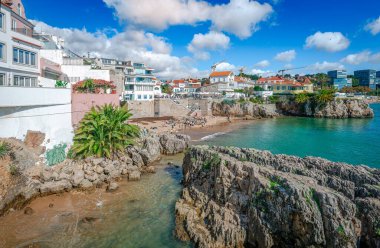 Cascais, Portekiz - 27 Ekim 2024: Portekiz Rivierası 'nın pitoresk kasabasında denize bakan eski ve modern konut. Fotoğrafın merkezinde Praia da Rainha var..