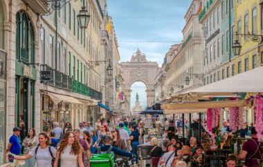 Lizbon, Portekiz - 24 Ekim 2024: Rua Augusta, Portekiz 'in geleneksel kaldırım taşı tasarımlarıyla döşenmiş ve oteller, restoranlar ve kaldırım kafeleri ile kaplanmış, şehrin en canlı yaya sokağı..