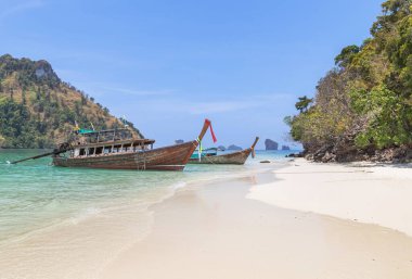 Tahta uzun kuyruklu tekneler Tayland 'ın deniz krabilerinde kıyıya yanaşıyor.