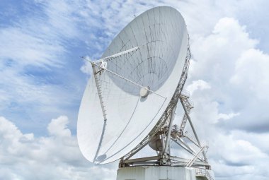 Büyük, beyaz uydu antenleri iletişim anten merkezi istasyonunda mavi gökyüzünde gökyüzüne doğru dönüyor.