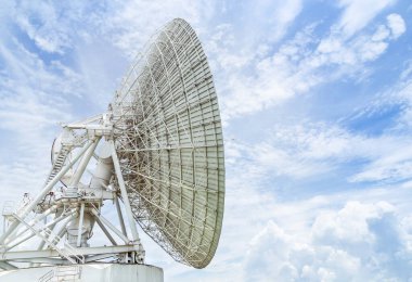 Büyük radyo antenli astronomi çanağı mavi gökyüzünde gökyüzüne doğru dönüyor. 