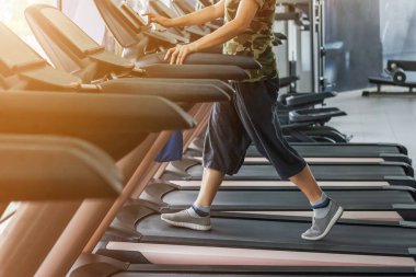 Vücut geliştirme için koşu bandı ekipmanı takibi üzerinde egzersiz yapan kadın egzersizi. 