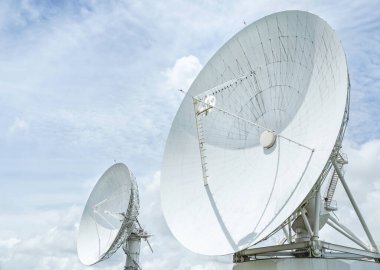 Large radio antenna astronomy dishs turn up skyward on blue sky in earth communication antenna system center station clipart