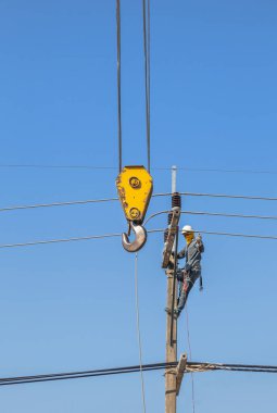 Çalışma yüksekliği sarı büyük vinç ile beton elektrik enerjisi direğe tırmanma elektrikçiler