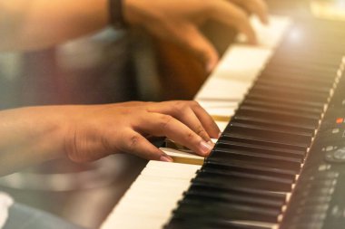 Gece konserinde orkestrada klavye sentezleyicisi çalan piyanistin ellerini kapat.