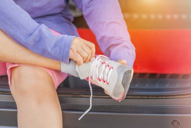 sporty woman sitting tying shoelaces before training cardio exercise workout clipart