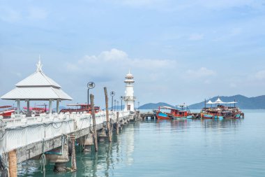 Bang Bao balıkçı köyünün rıhtımındaki beyaz deniz fenerinin manzarası. Koh Chang Adası, Trat, Tayland 'da balıkçı tekneleri var.