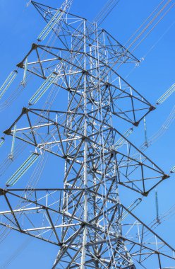               High voltage electrical pylon in electric power plants power substation on blue sky background   clipart