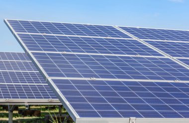 Güneş enerjisi istasyonundaki sıra sıra güneş pillerini veya fotovoltaikleri kapat 