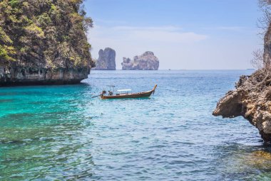               Landscape viewpoint of loh samah bay with longtail boat and turquoise blue lagoon is famous tour snorkeling point at phi phi island, krabi Thailand  clipart