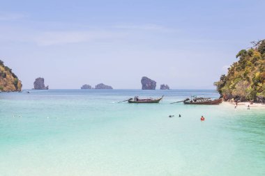 Uzun kuyruklu tekne Tayland 'ın Yengeç Adası tropikal sahilinde demirliyor.