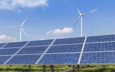      Çok kristalli silikon güneş panelleri ve rüzgar türbinlerinden oluşan sıralar hibrit enerji santrali istasyonunda alternatif yenilenebilir rüzgar enerjisi ve mavi gökyüzünde güneş ışığı enerjisi üretiyor.