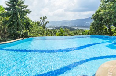 Lüks sonsuzluk havuzu tropikal doğa manzarasına bakıyor.