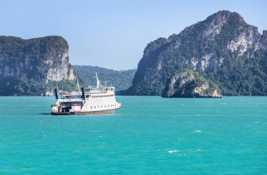 ferryboat carrying passengers and cars crossing in blue sea  between Samui island and Surat Thani province, Thailand  clipart