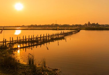 Gün batımında Maha Sarakham, Tayland 'daki eski ahşap köprü manzarası.