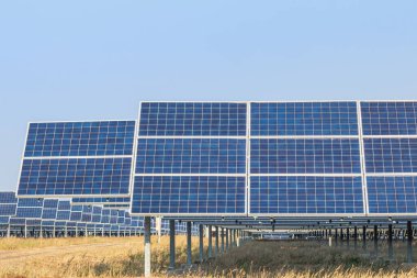 Güneş enerjisi istasyonundaki sıra sıra güneş pilleri veya fotovoltaikler alternatif temiz yenilenebilir enerji verimliliği