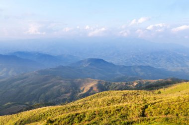 Tayland yakınlarındaki dağda çim çayır yamacında gün batımı manzarası Doi Chang Moob, Mae Sai, Chiang Rai, Tayland    