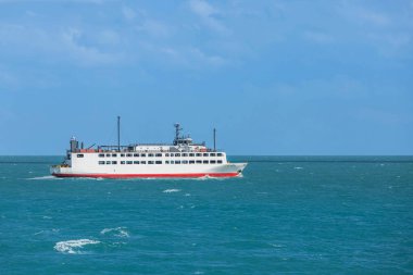 Mavi denizde yolcu ve araba taşıyan büyük bir feribot. 