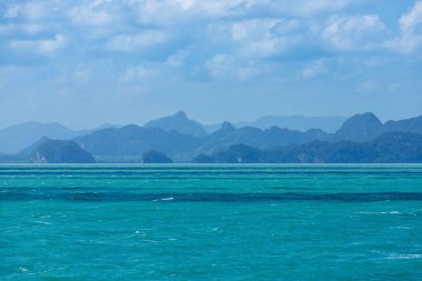 Turkuaz denizdeki dalgalanmanın deniz manzarası. Bir sürü tepe adası ve sabahları katman katman dağ arkaplanı.