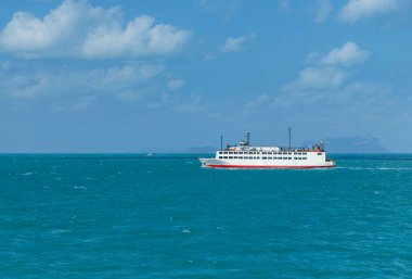 Mavi denizde yolcu ve araba taşıyan büyük bir feribot.  