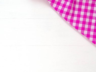 Üst manzara, pembe ve beyaz kareli kumaş veya beyaz masa arkaplanındaki peçete. Mutfak gereçleri ve sofra takımları hariç. Üst görünüm, kopyalama alanı olan düz uzanma
