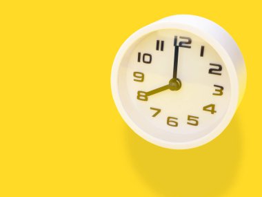 Kapatın, saat 8: 00 'de ofis sarısı çalışma masasında beyaz saat gösterimi var. Metnin için alanı kopyala. İş ve eğitim kavramı.